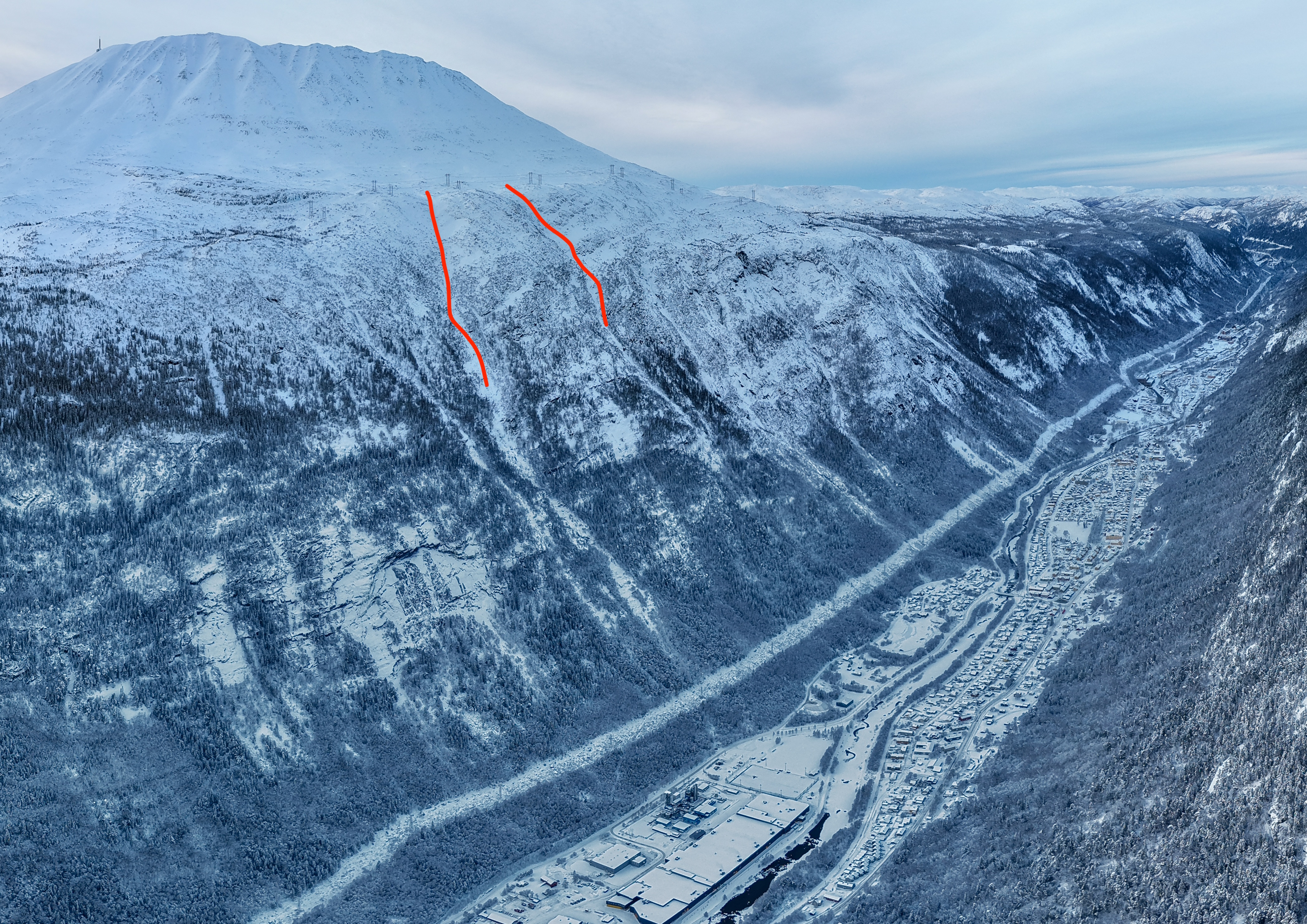 Aerial view of snowy slopes above Svadde and the Rjukan valley, with two red annotations on the mountainside